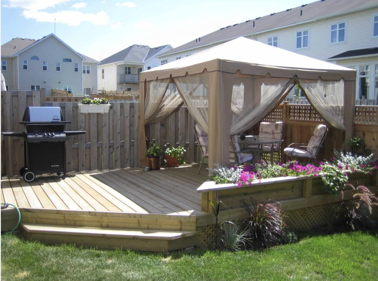 Ground-Level Deck & Gazebo installed in Barrhaven, Ontario by Fence Masters Ottawa — Pressure-treated deck with wide entry steps, planter box and a shaded gazebo lounge