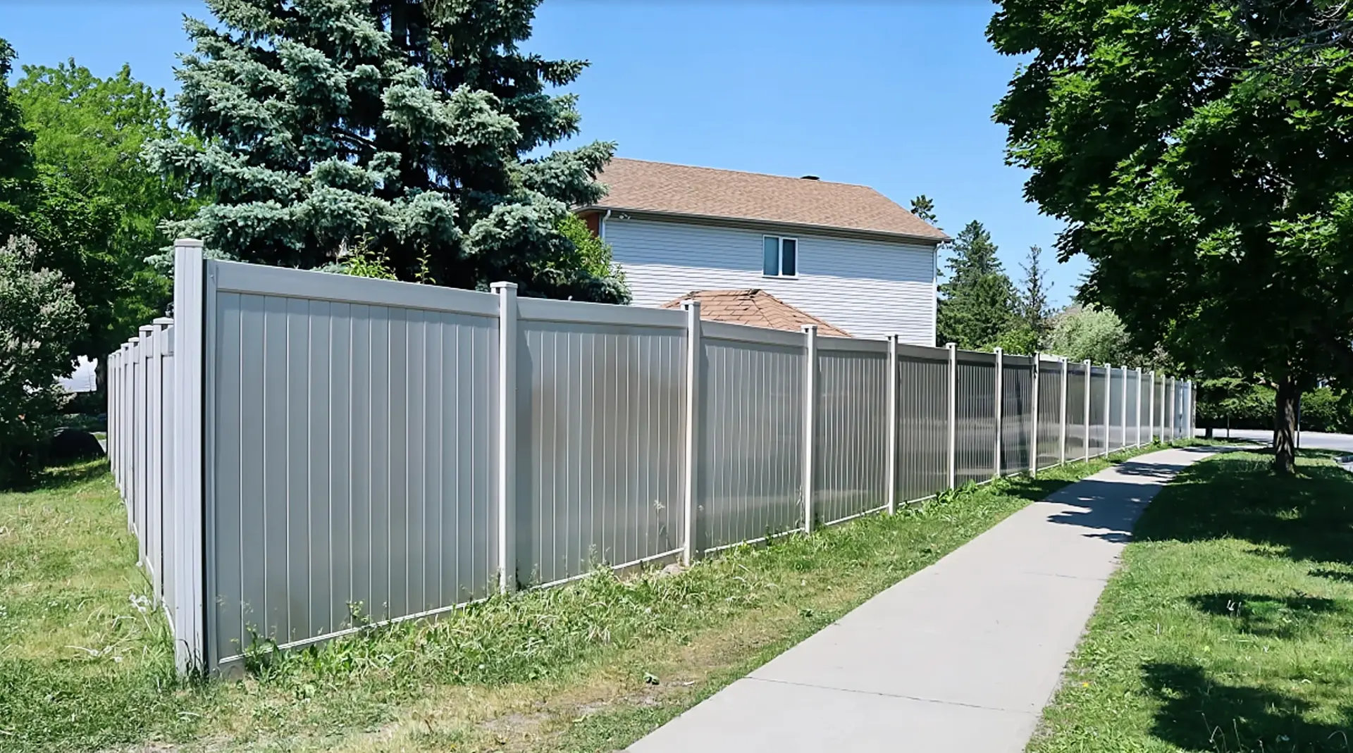Grey PVC privacy fence installed by Fence Masters along a residential sidewalk in Ottawa