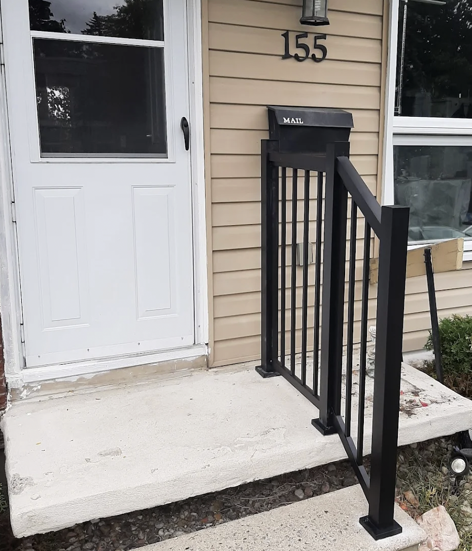 Black aluminum entry railing positioned within easy reach beside the front door