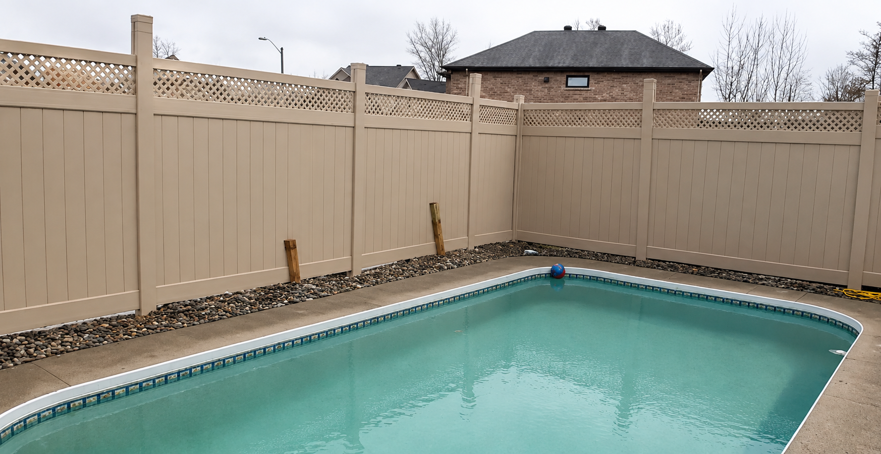 Tan lattice-top PVC privacy fence enclosing an inground pool in an Ottawa backyard
